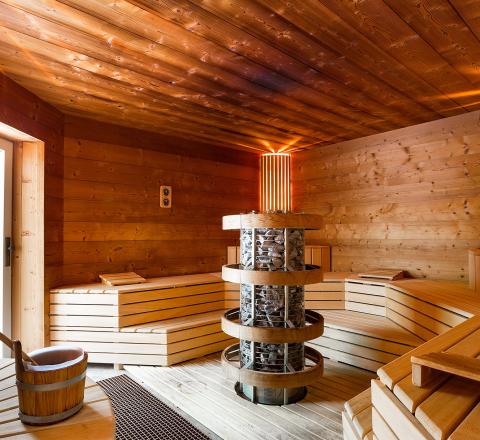 Wohltuende Hitze, natürliches Holz und alpine Ruhe: Die finnische Steinofensauna für echte Erholung.